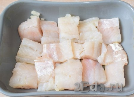 Выложите на лук нарезанные кусочки филе судака.